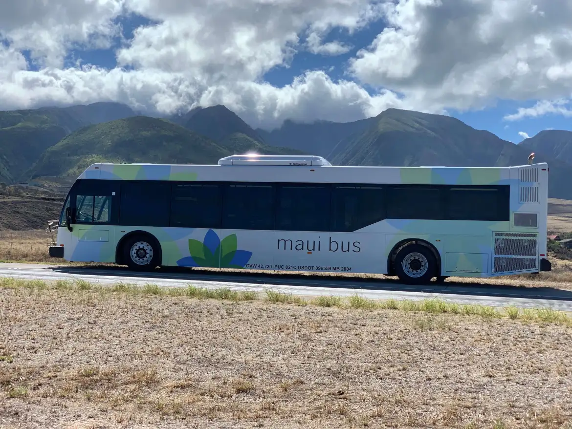 the ENC large transit bus is backed by beautiful maui mountains, stunning views await